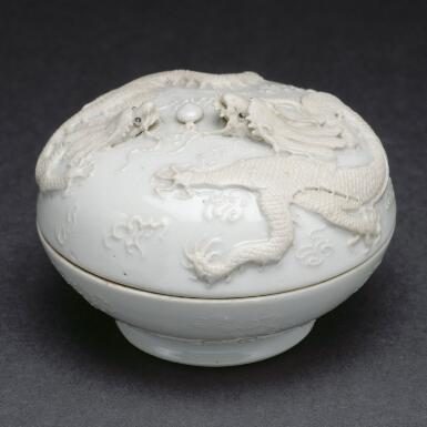 Bol en céramique blanche avec décor en relief de dragon et fleurs.